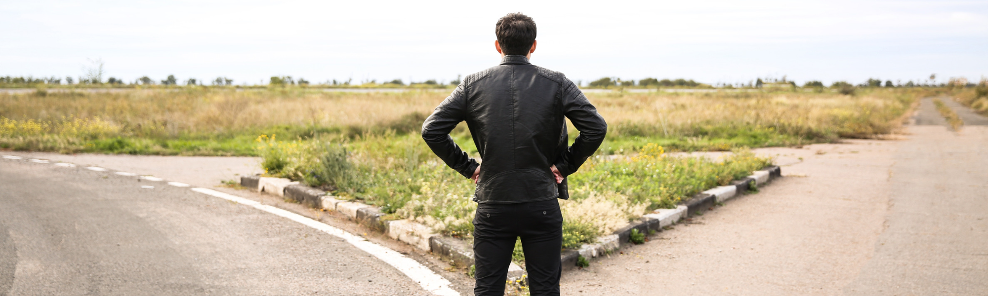 A student standing at a crossroads forked road