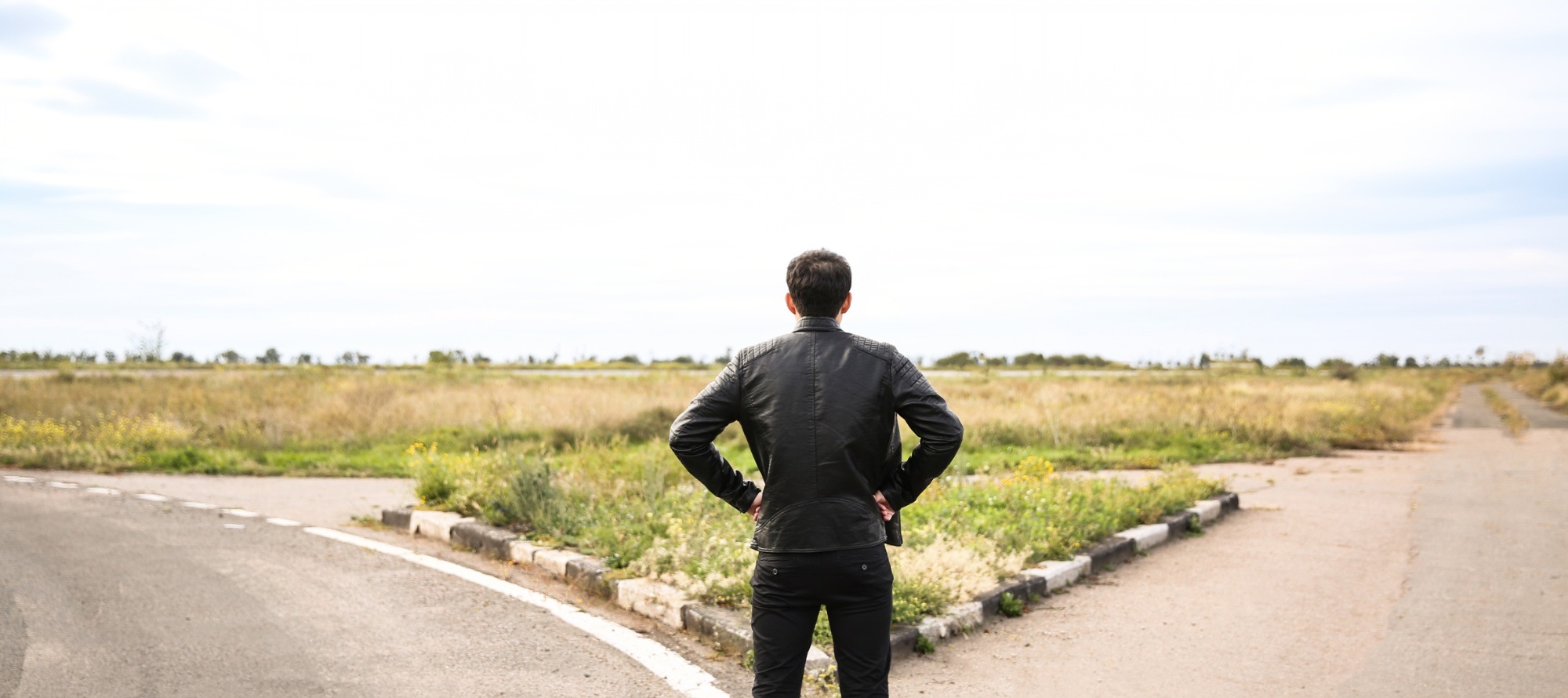 A student standing at a crossroads forked road